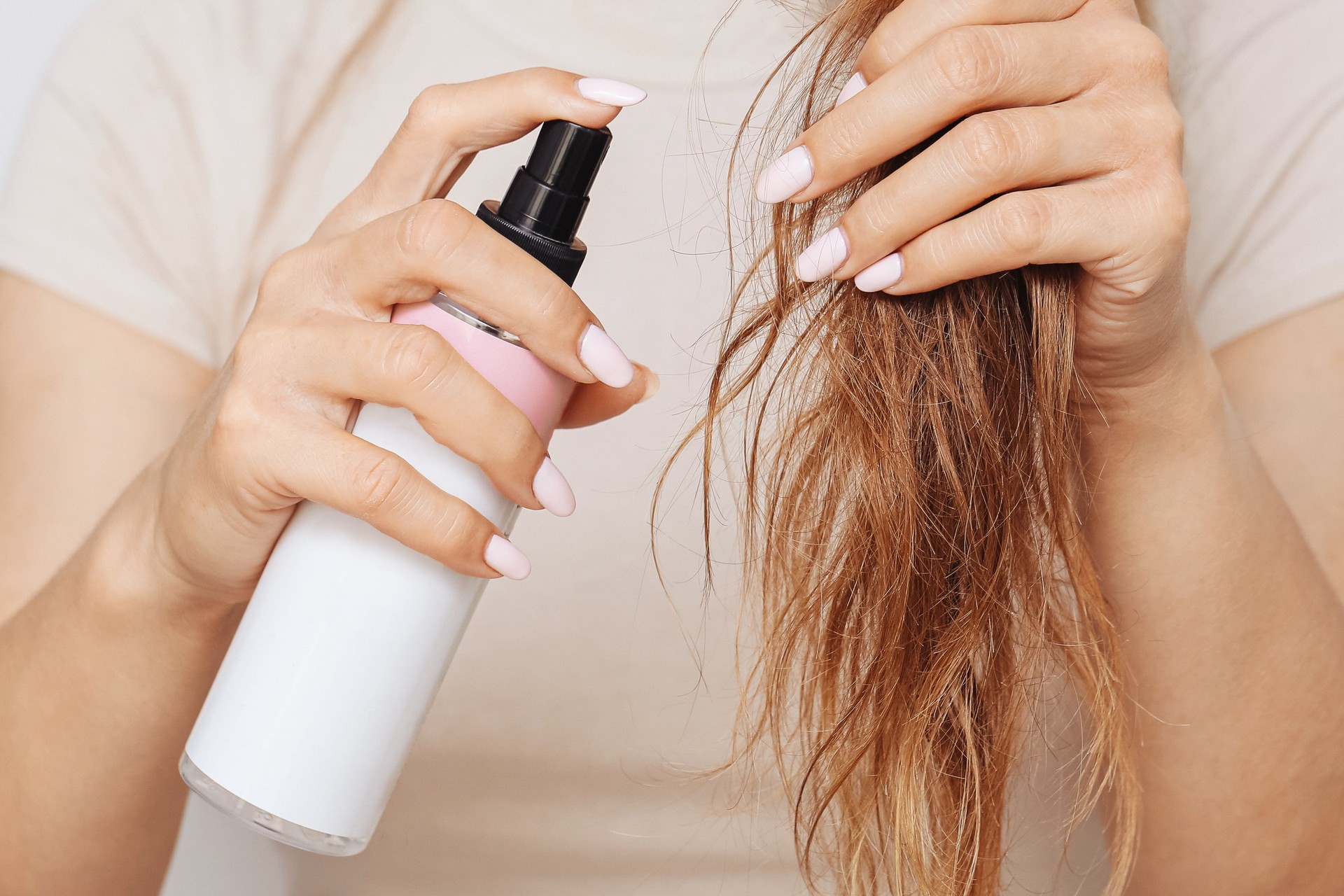Hair care with spray. Woman applies cosmetic mist. Healthy routine with nourishing conditioner.